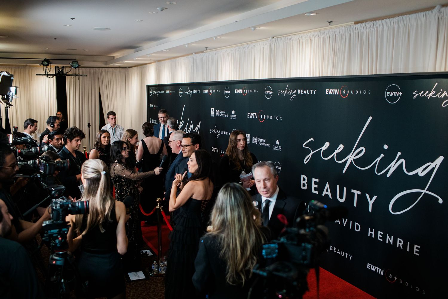 Photographers and press gather on a red carpet at a movie premiere event.