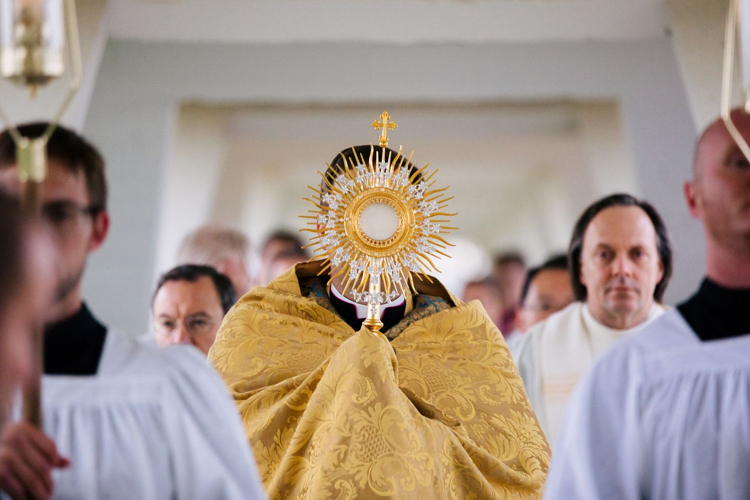 A series of religious ceremony photos featuring golden ornate monstrance displays and white-robed clergy members.