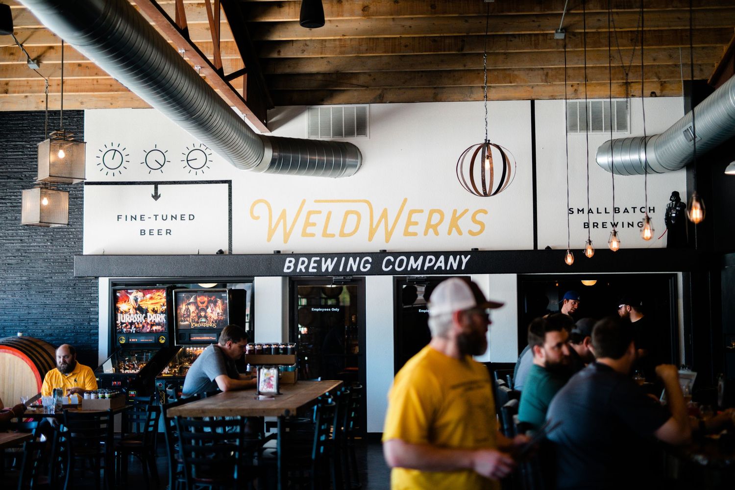 Interior view of a modern craft brewery taproom with industrial decor and bar seating.