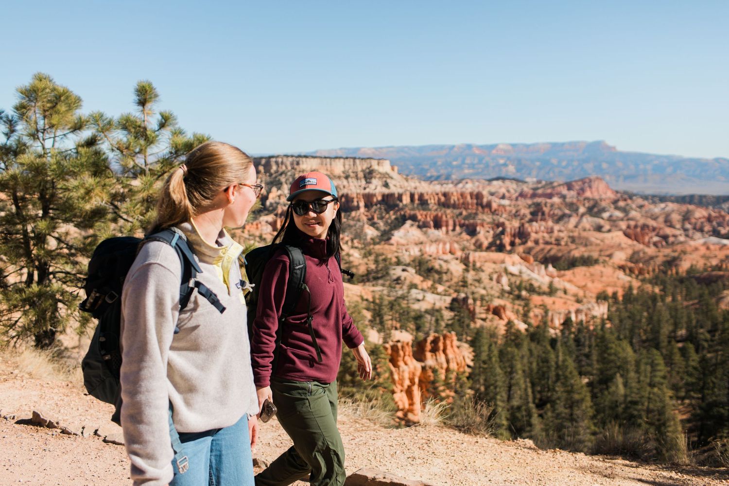 Two people admire the stunning red rock formations and scenic vistas at Bryce Canyon National Park in Utah.