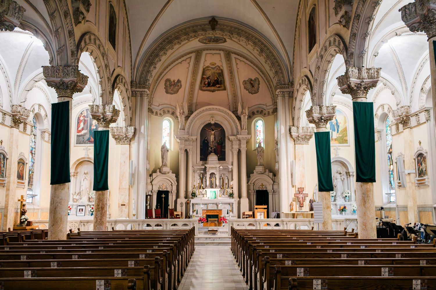 Wide panoramic view of a traditional church interior with wooden pews and vaulted ceiling architecture.