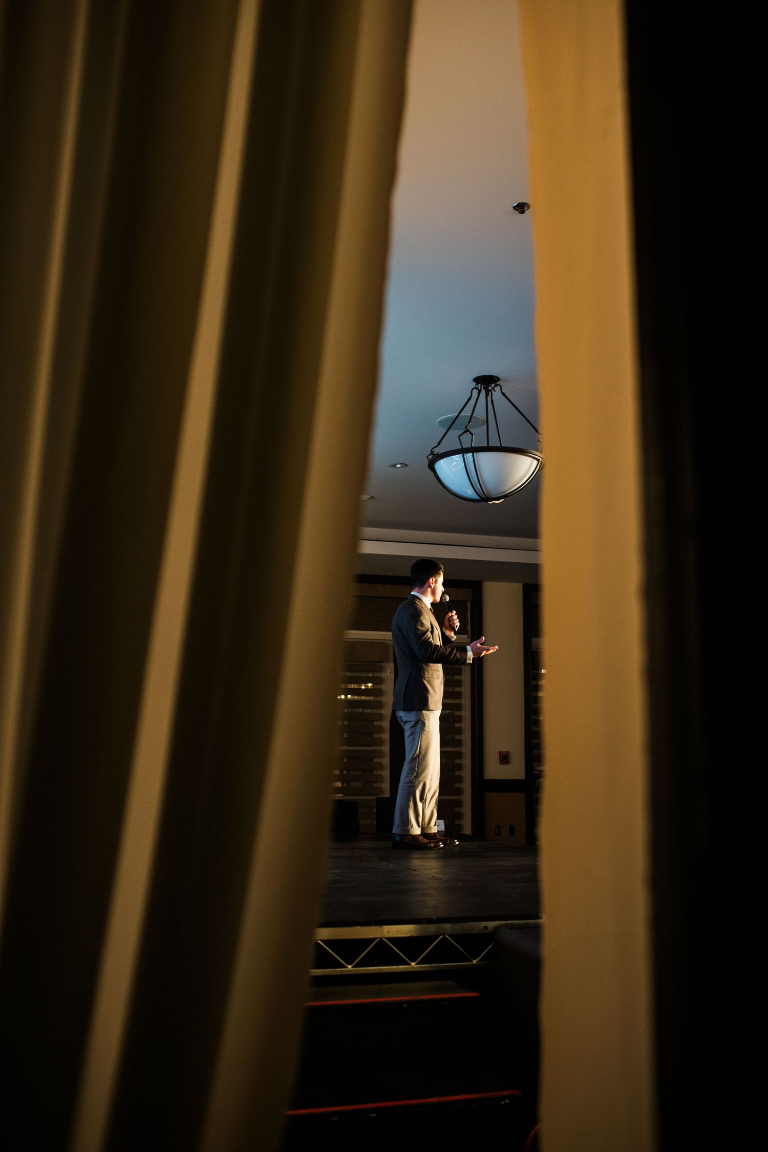 Dramatic silhouette shot through vertical pillars or columns in a dimly lit interior space.