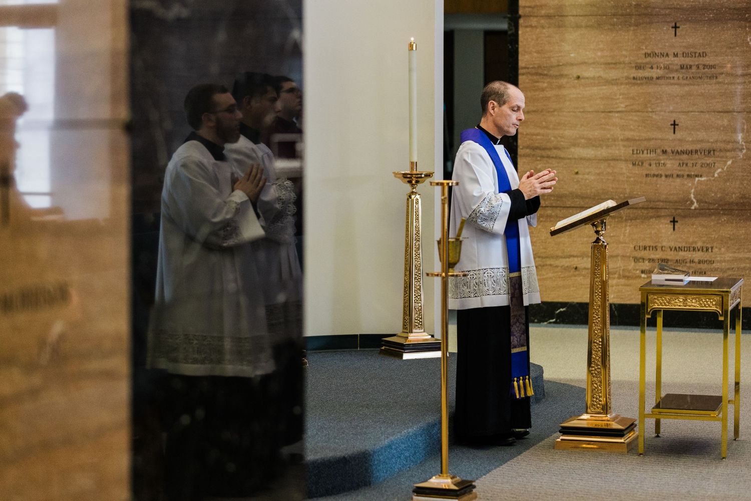 A sequence of shots showing a prayer and worship service inside a wooden paneled church.