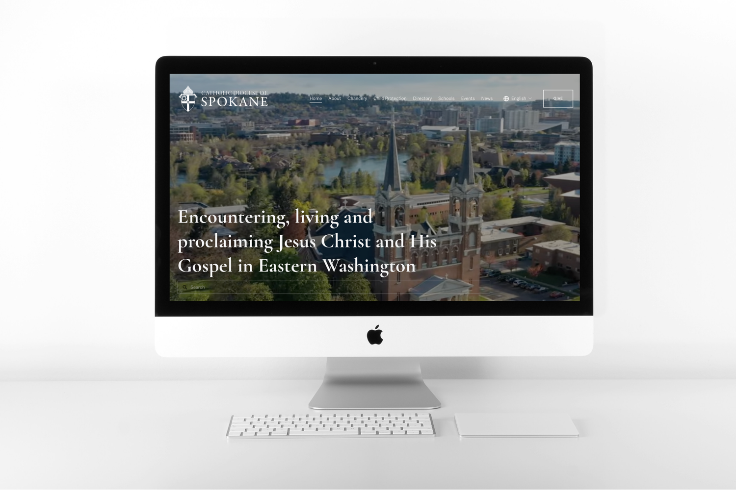 Computer monitor displaying religious organization website homepage with cityscape background.