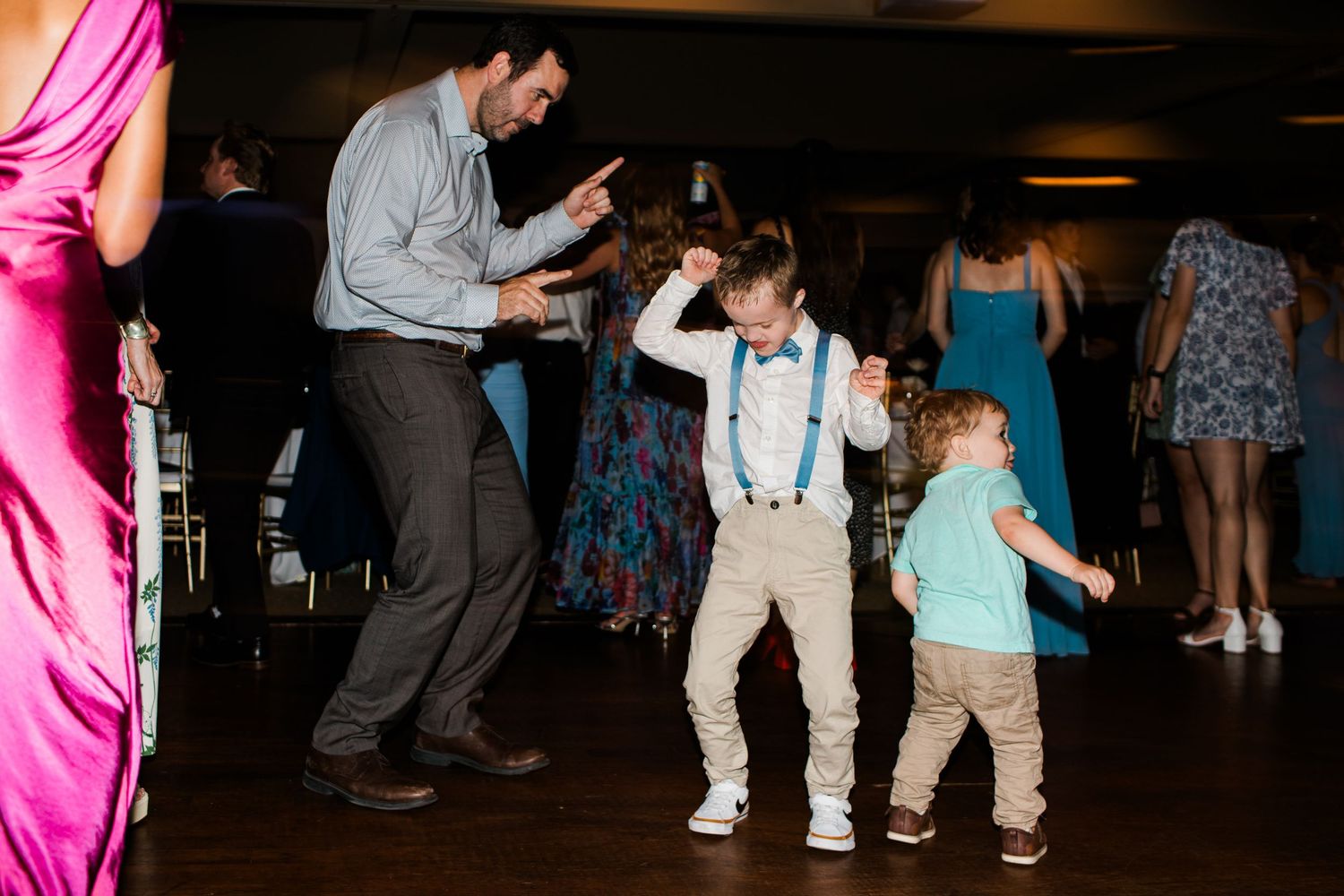 Children and adult dancing joyfully on the wedding reception dance floor during celebrations.