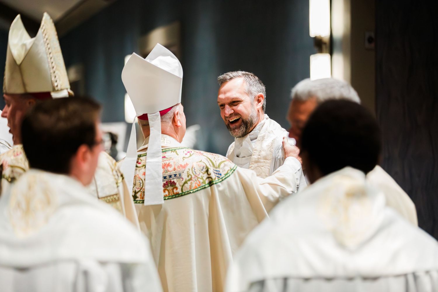 Religious figures in white robes gather during a ceremonial service at a church.