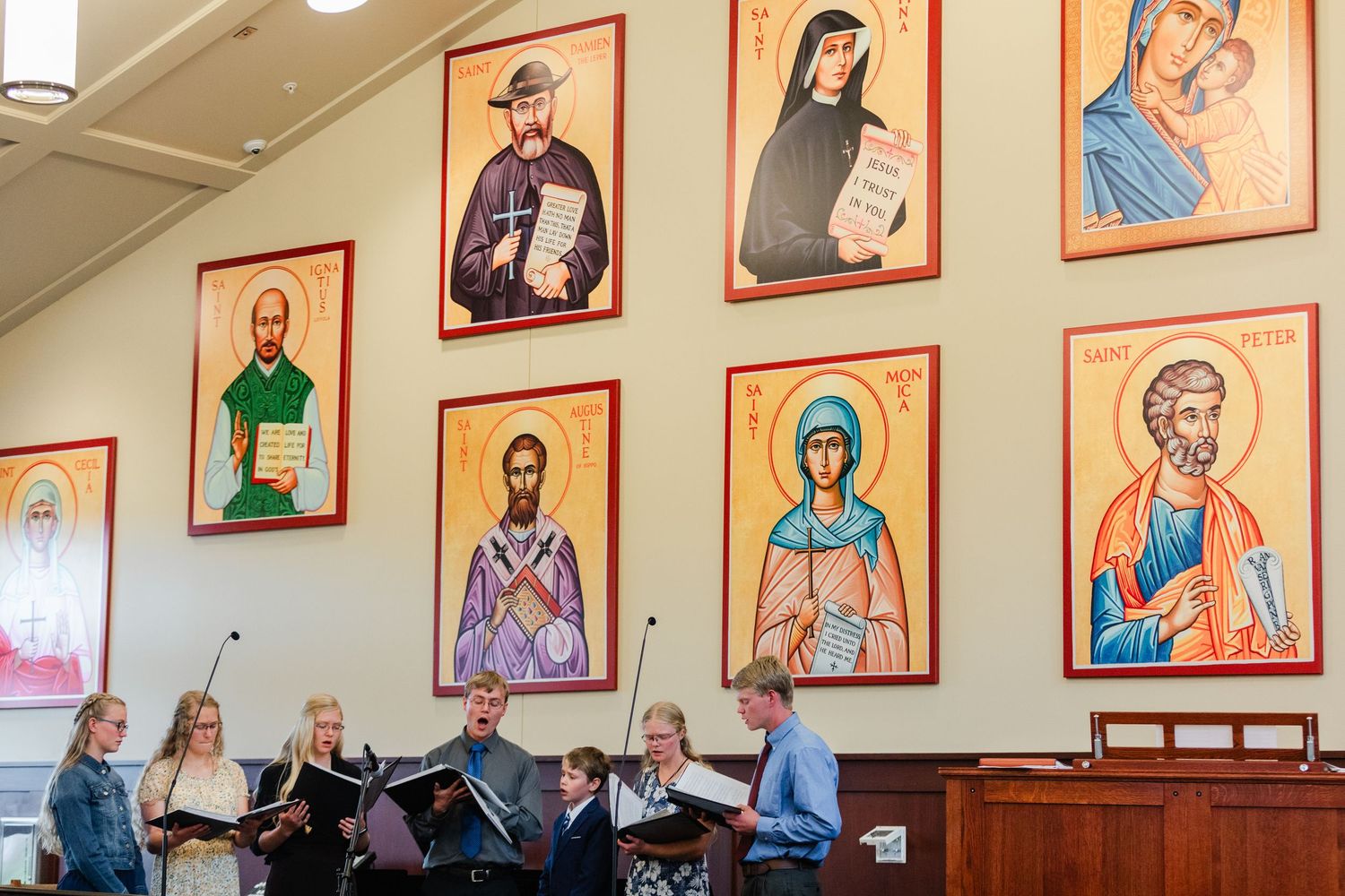 Religious artwork and portraits of saints line the walls of an Orthodox Christian church interior.