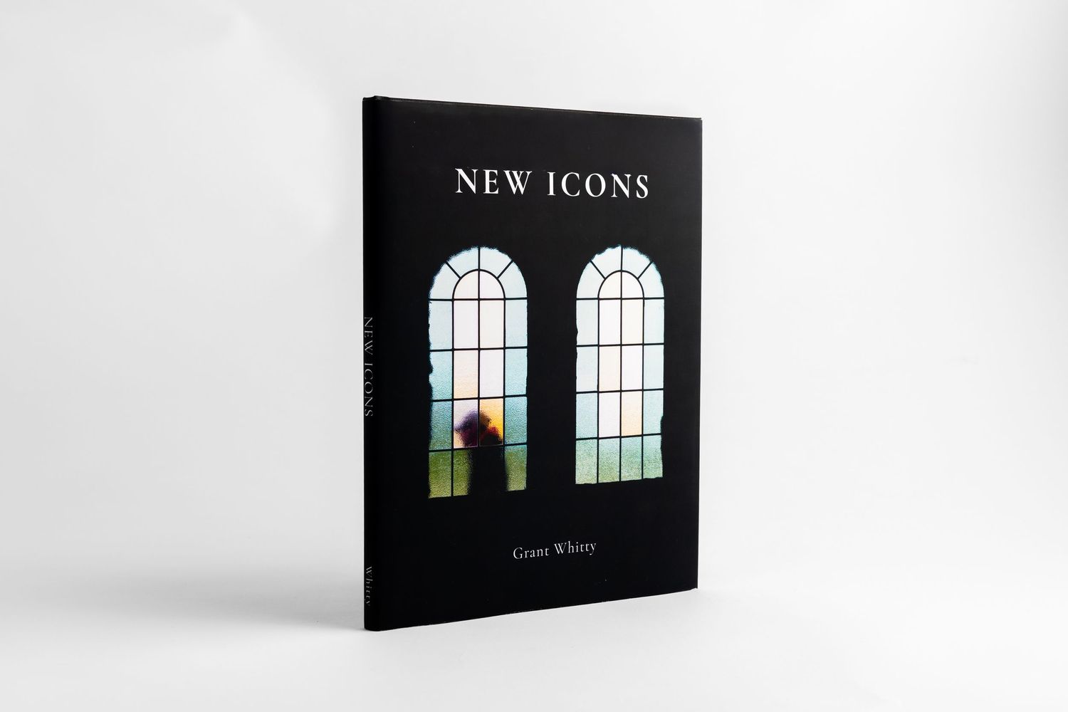 A black hardcover book titled 'NEW ICONS' shown from different angles with minimalist window designs on its cover.