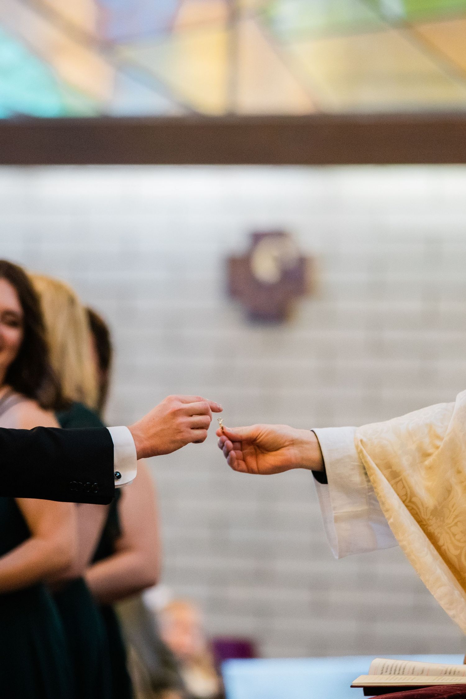 Hands reach out during communion or blessing ceremony in church setting.