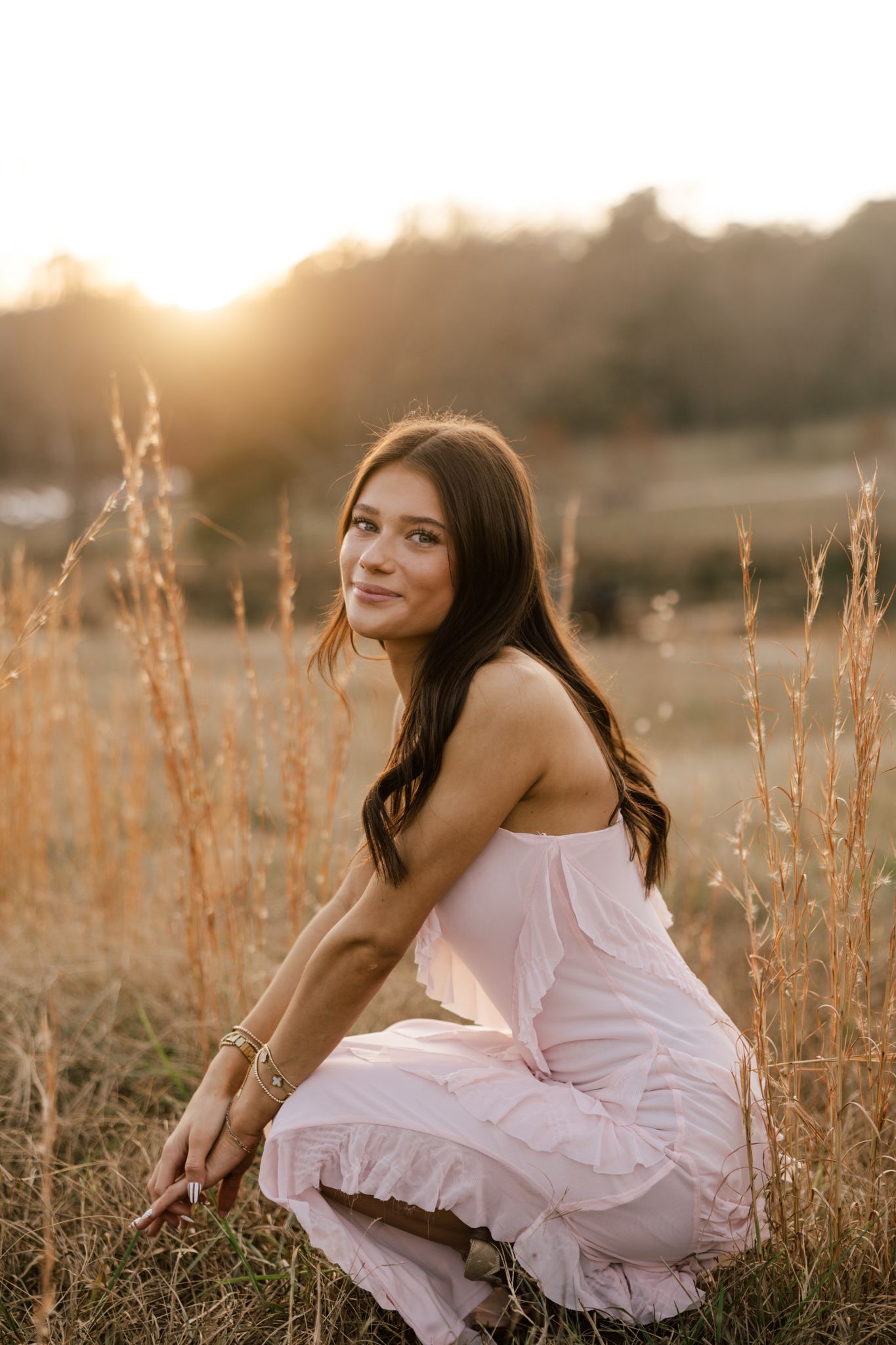 Sunset portrait in a golden field with tall grass and warm lighting.
