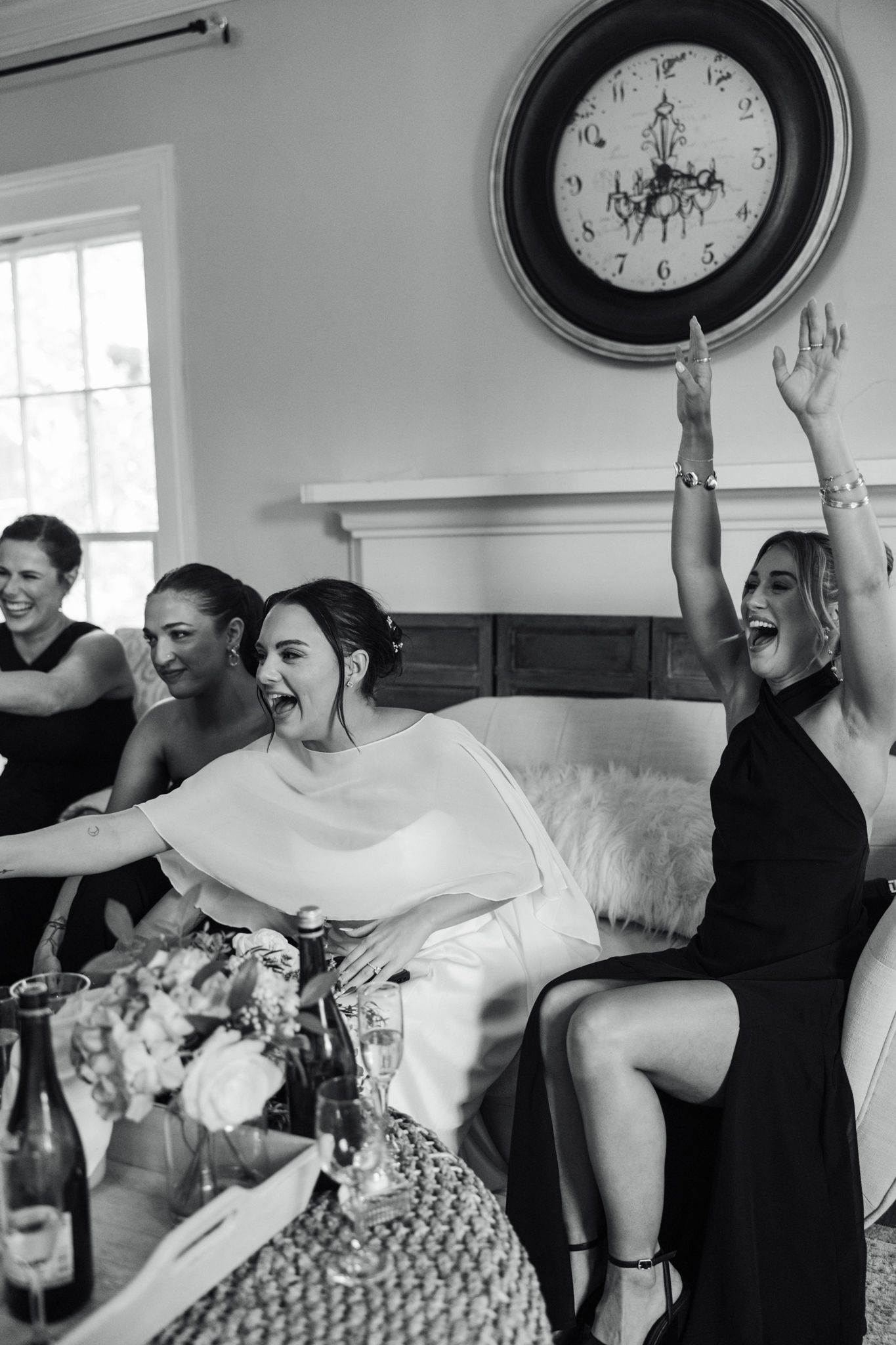 Wedding party members celebrate with playful poses and laughter under vintage wall clocks.