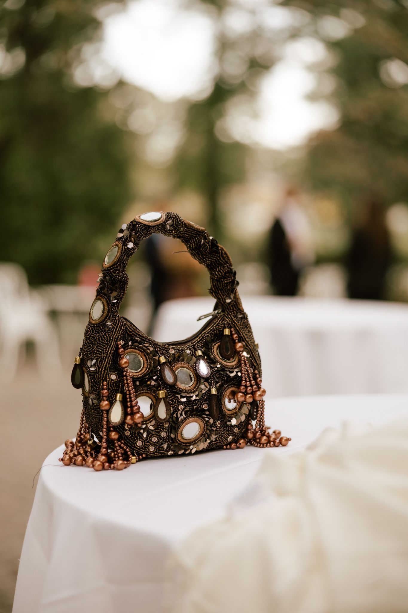 Ornate bronze crown with jewels and intricate details displayed on white fabric.