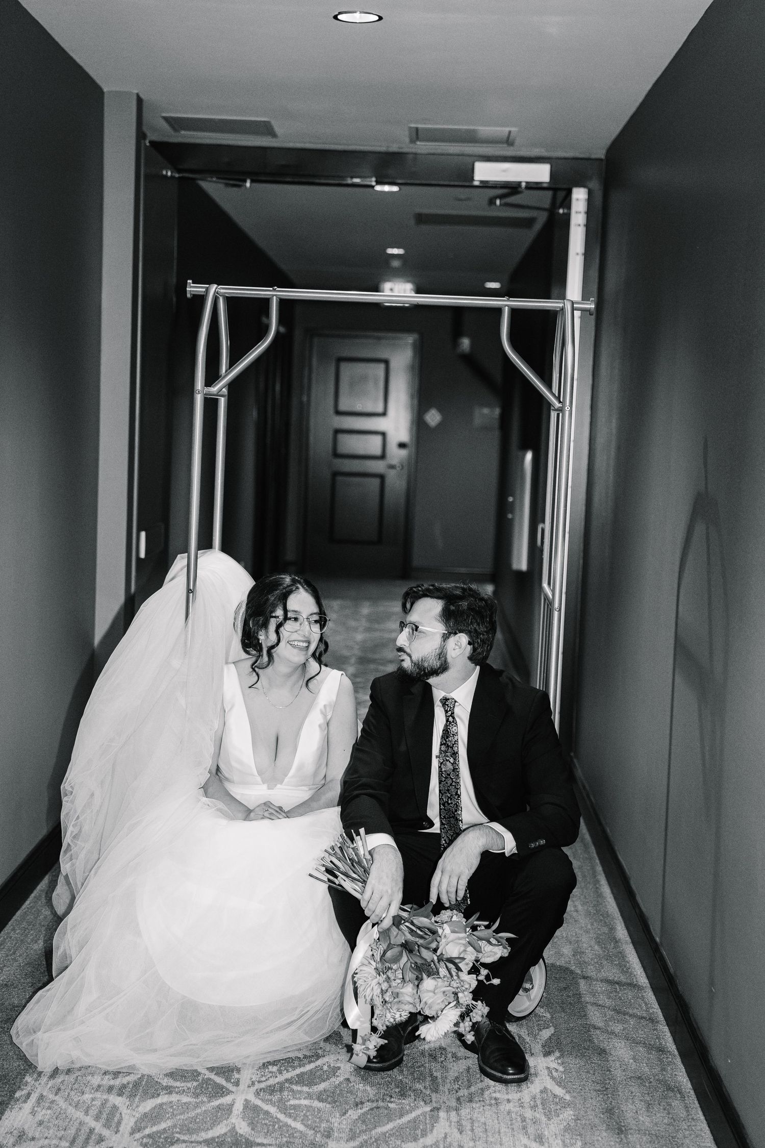 Black and white photo showing three connected images of a bride in a flowing white dress posing in a hotel hallway.
