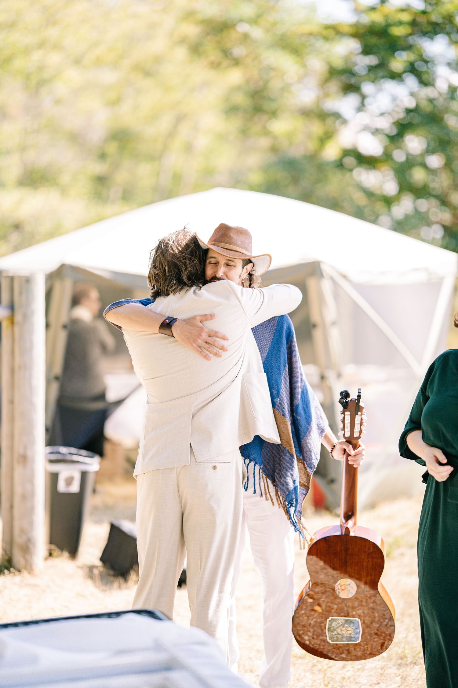 A series of artistic photographs showing white fabric flowing in the wind with a rustic banjo instrument.