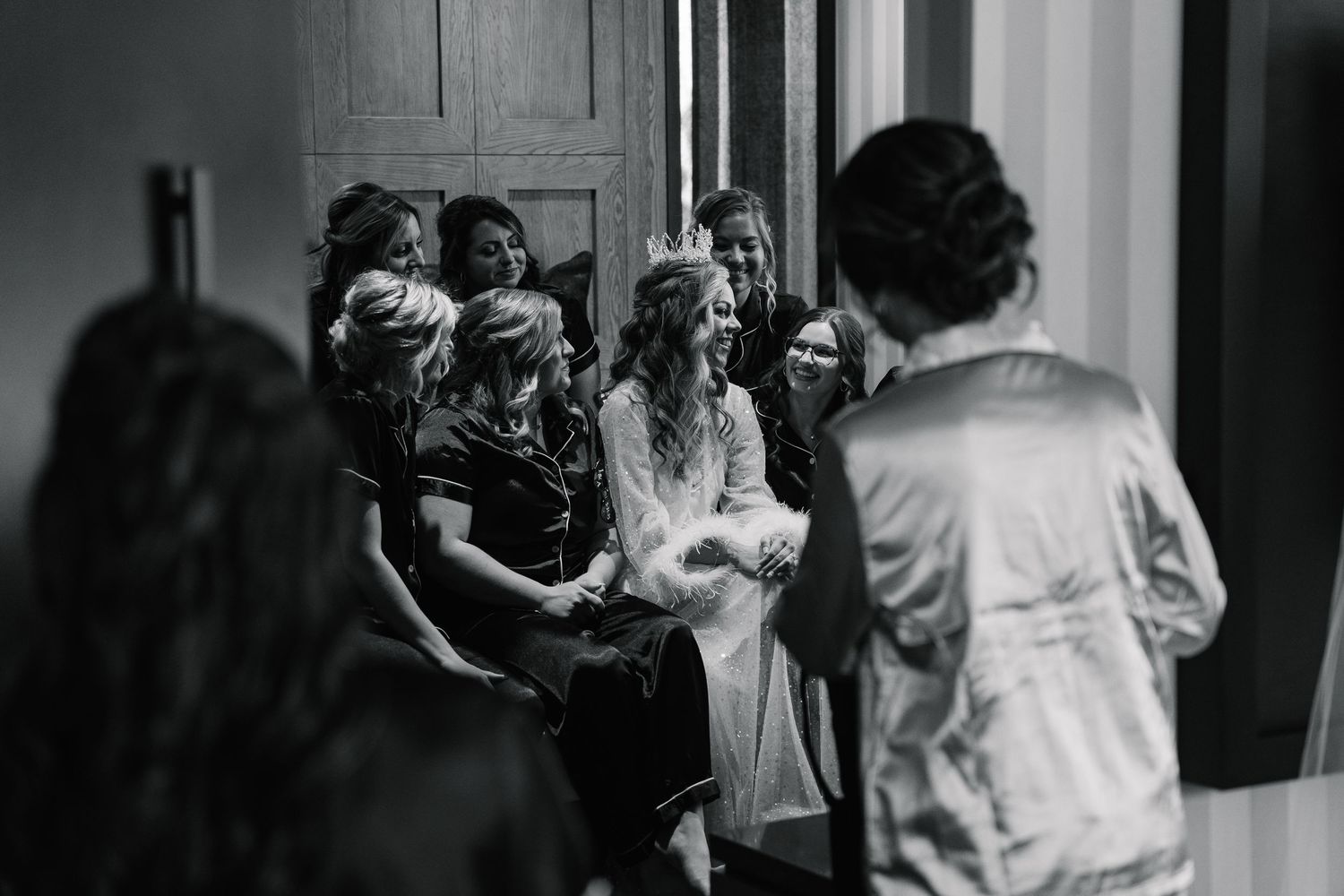 Wedding preparation scene with people getting ready in a dimly lit room.