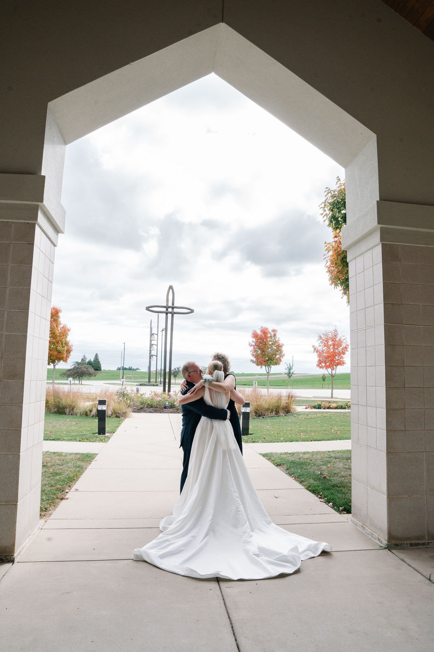 A sequence of wedding dress photos taken through architectural archways showing movement and flowing fabric.
