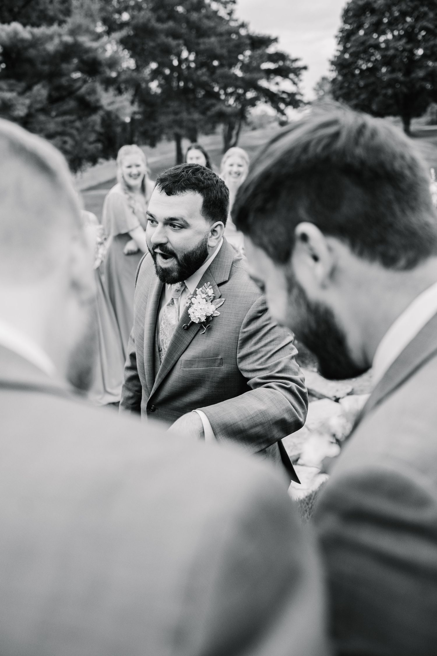 Black and white candid wedding photos showing emotional reactions and laughter during an outdoor celebration.