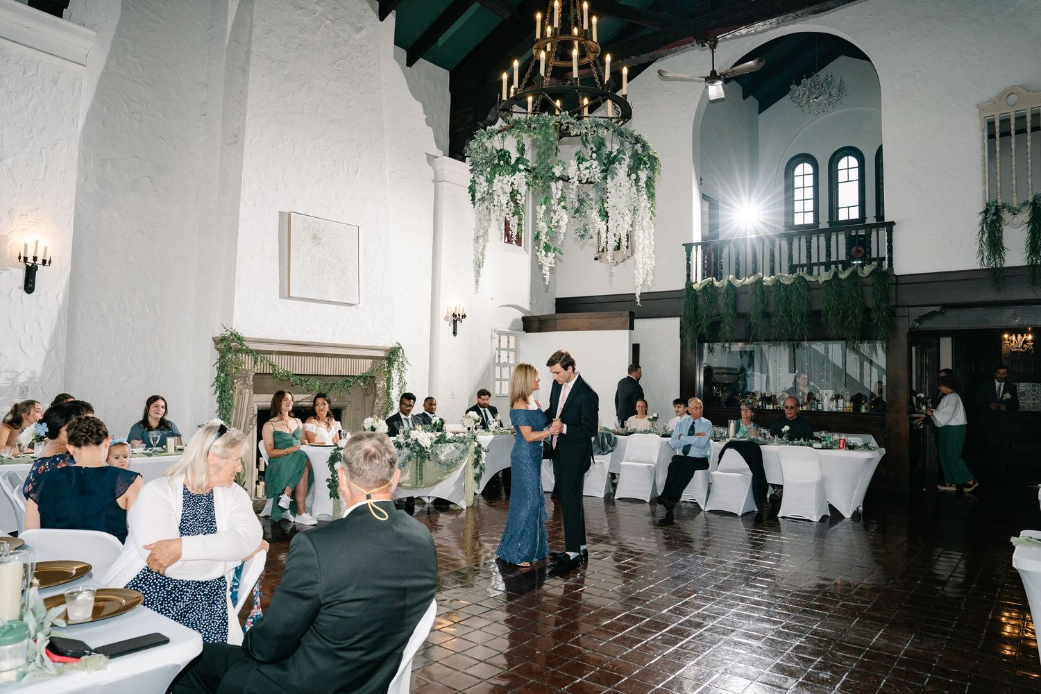 A montage of wedding reception moments showing an elegant ballroom with chandeliers and guests dancing on a wooden floor.