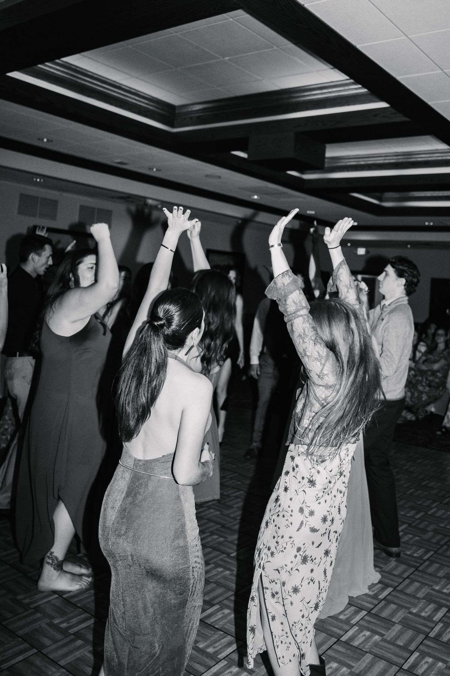 Black and white photos show people dancing with their hands raised at what appears to be a party or celebration event.