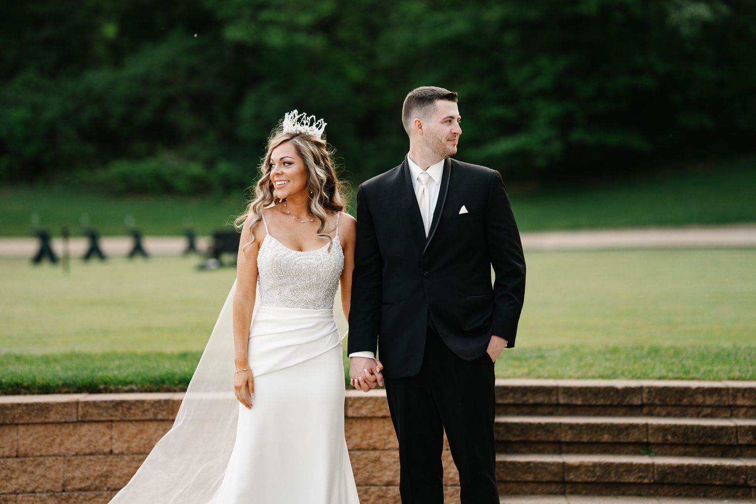 Newlyweds walk together on a lush golf course during their wedding photoshoot.