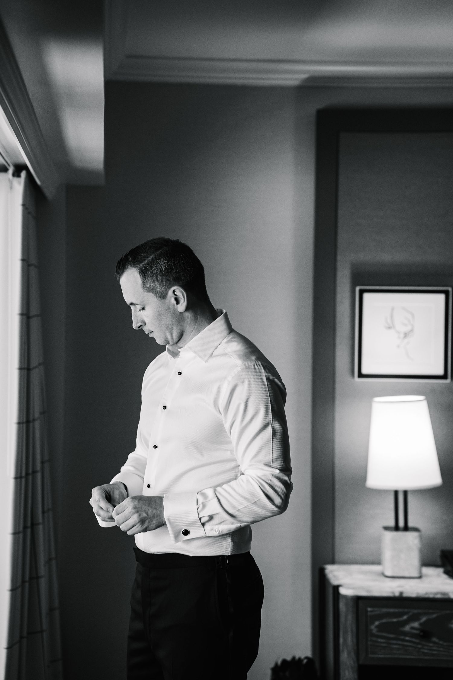 A sequence of black and white photos showing someone adjusting their formal dress shirt cuffs and sleeves.