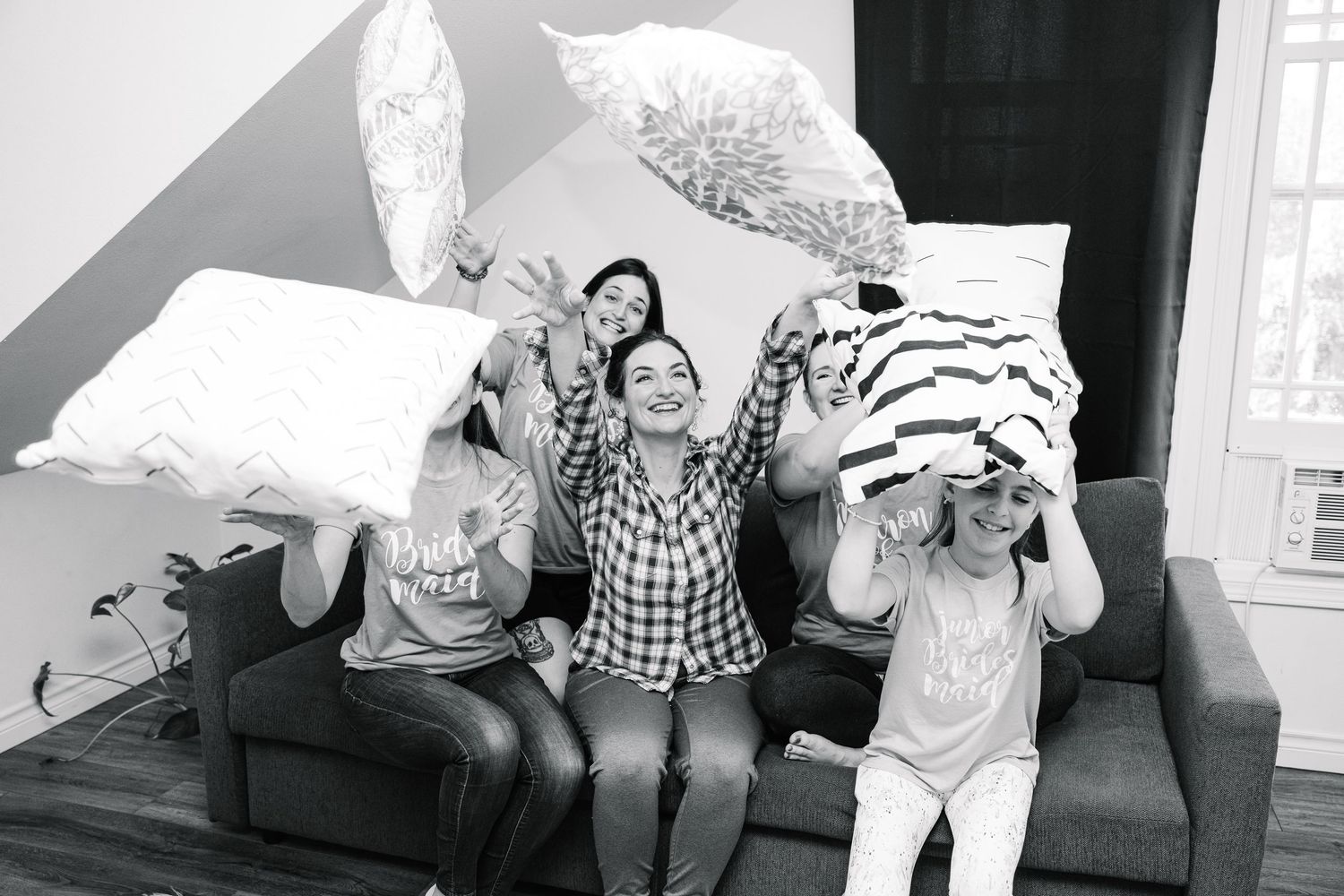 A series of playful black and white photographs showing people jumping and posing in various indoor settings.