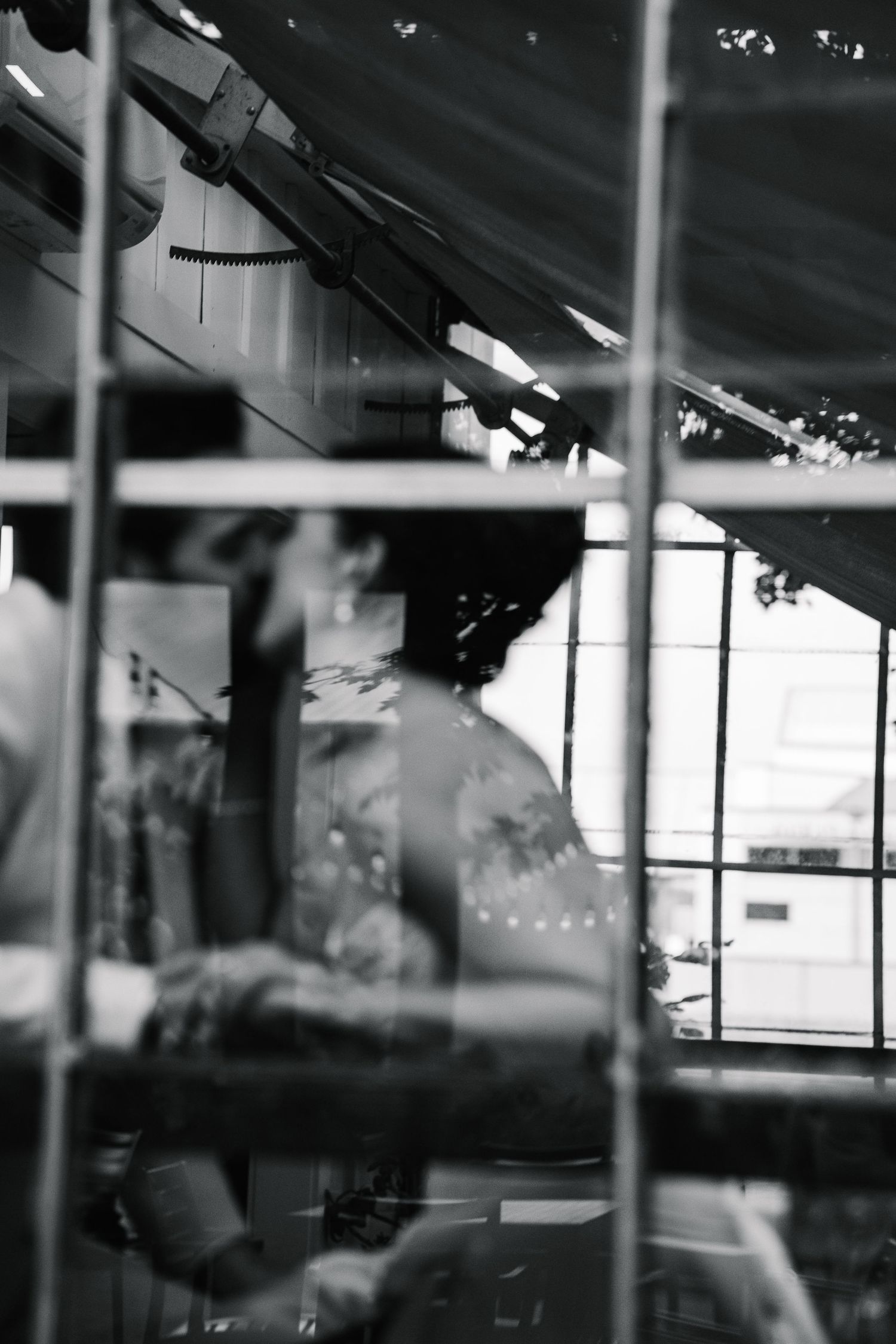 Blurred black and white interior scene with reflective glass windows and industrial architectural elements.