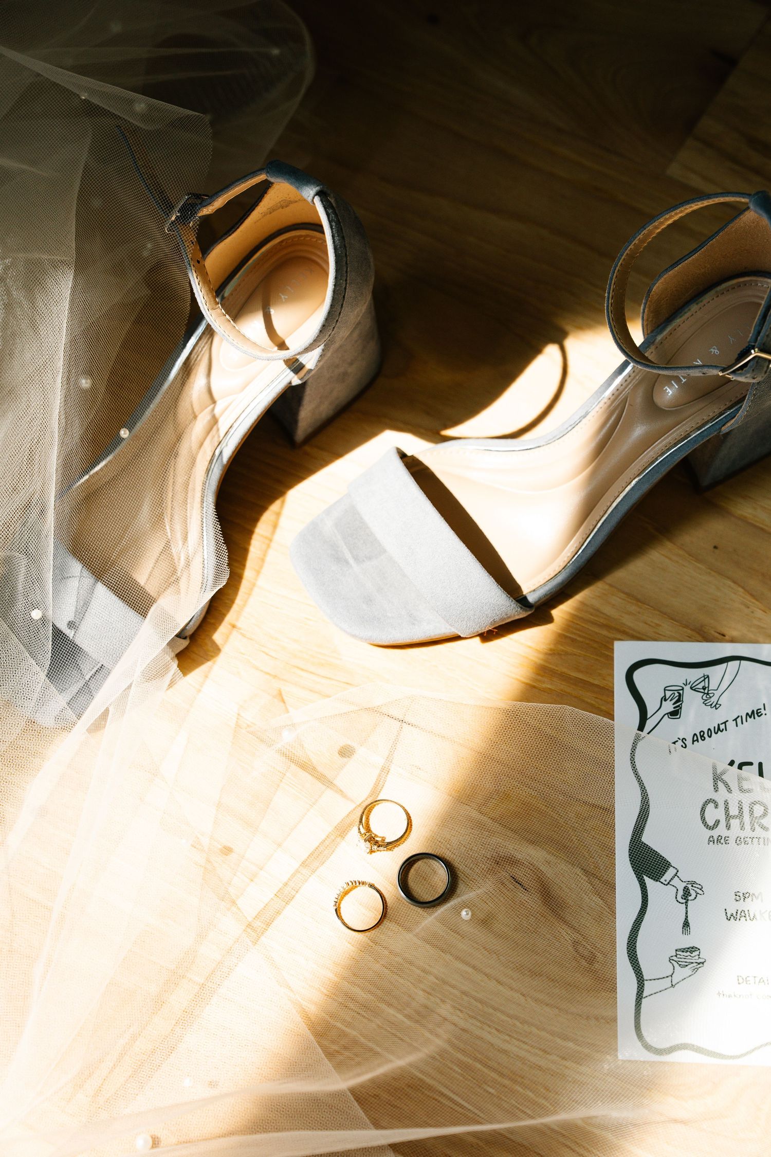 Sunlight streaming through a window creates dramatic shadows on a light wooden floor next to scattered papers.