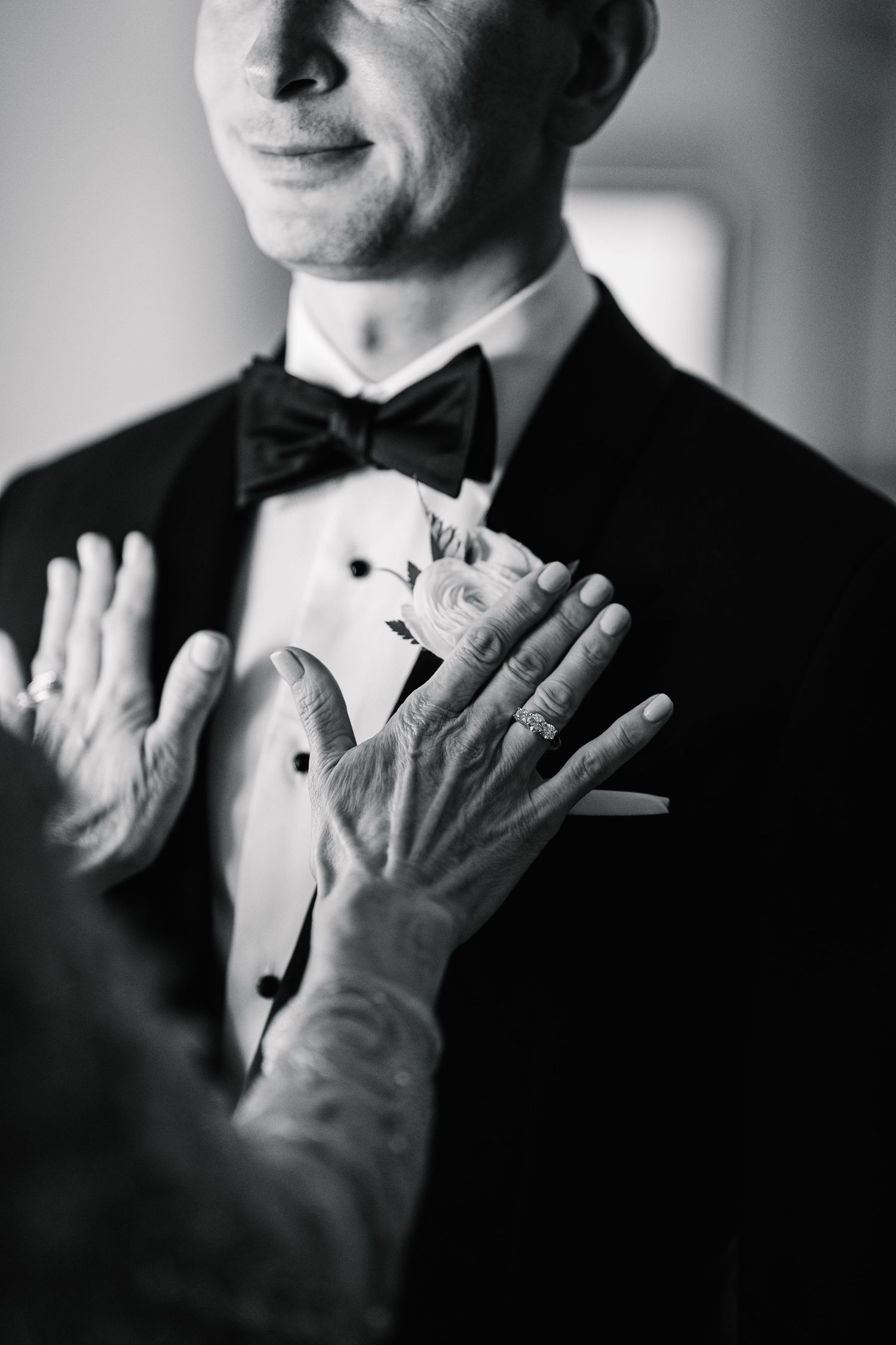 Black and white series showing hands adjusting a bowtie in formal attire.