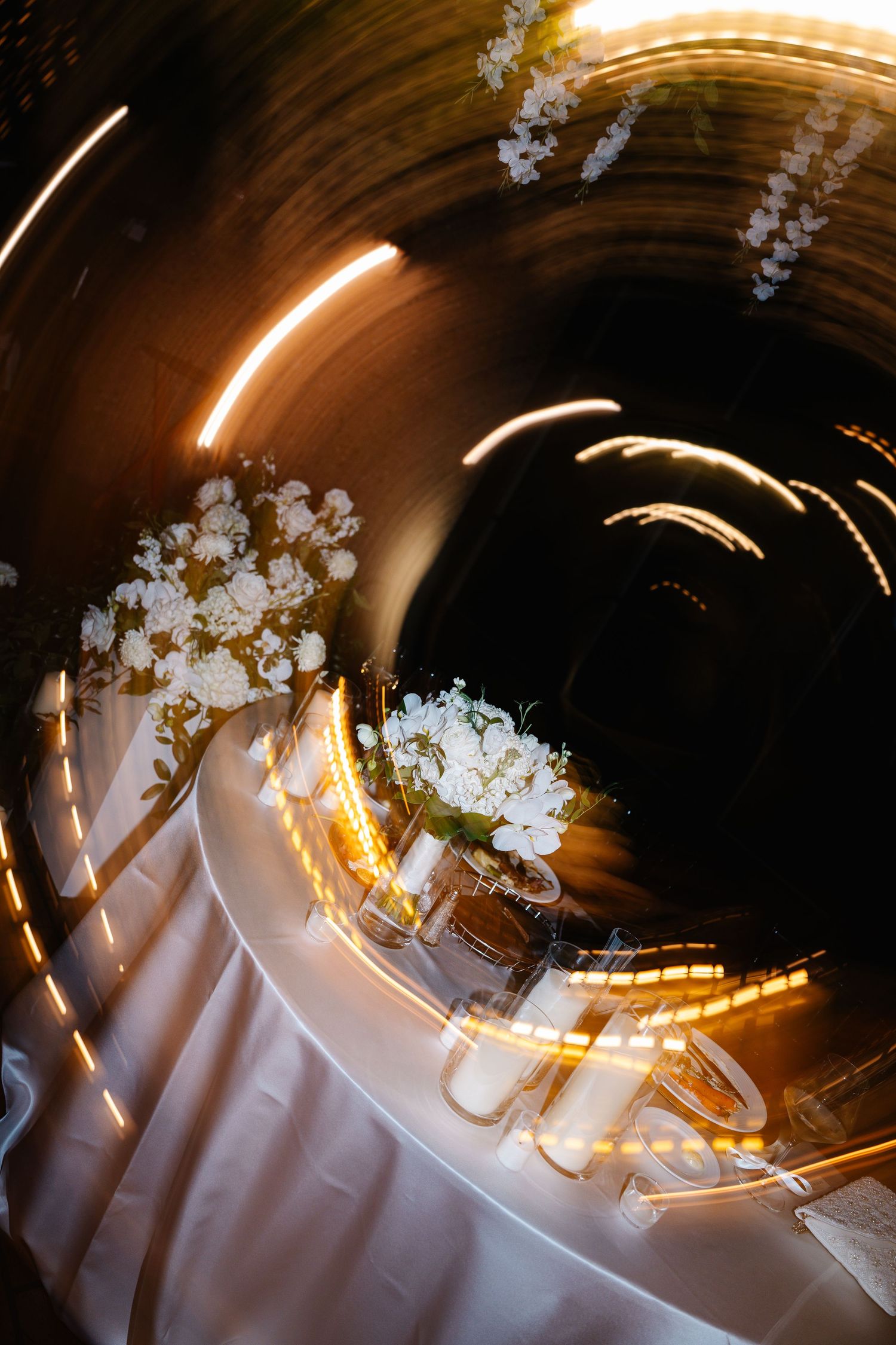 Abstract motion blur of lights and cherry blossoms creating circular patterns against a dark background.