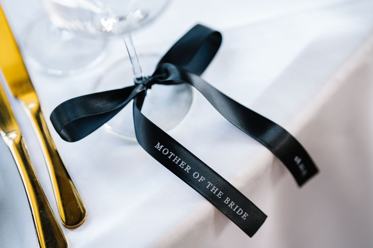 White gift boxes with black ribbons and bows arranged in an elegant display.