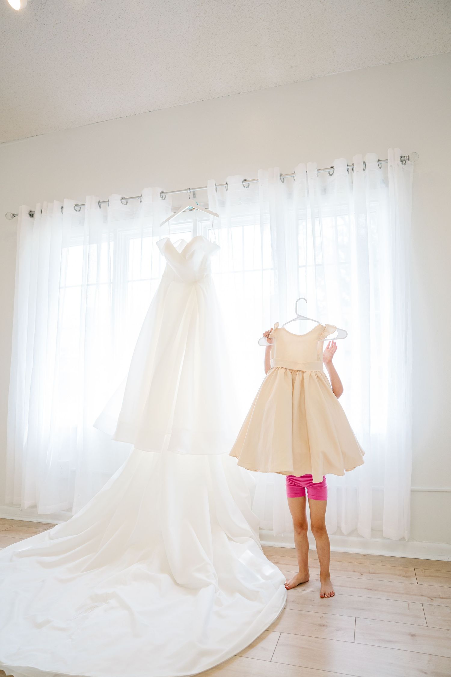 A series of wedding dress photos showing flowing white fabric and train details against a bright white room background.