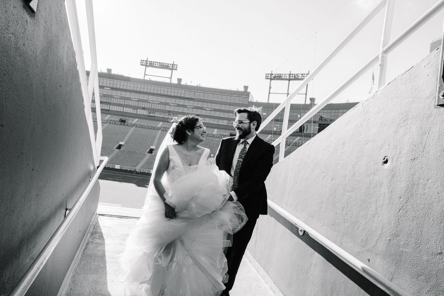 Black and white wedding photo sequence showing couple walking down exterior stairs.