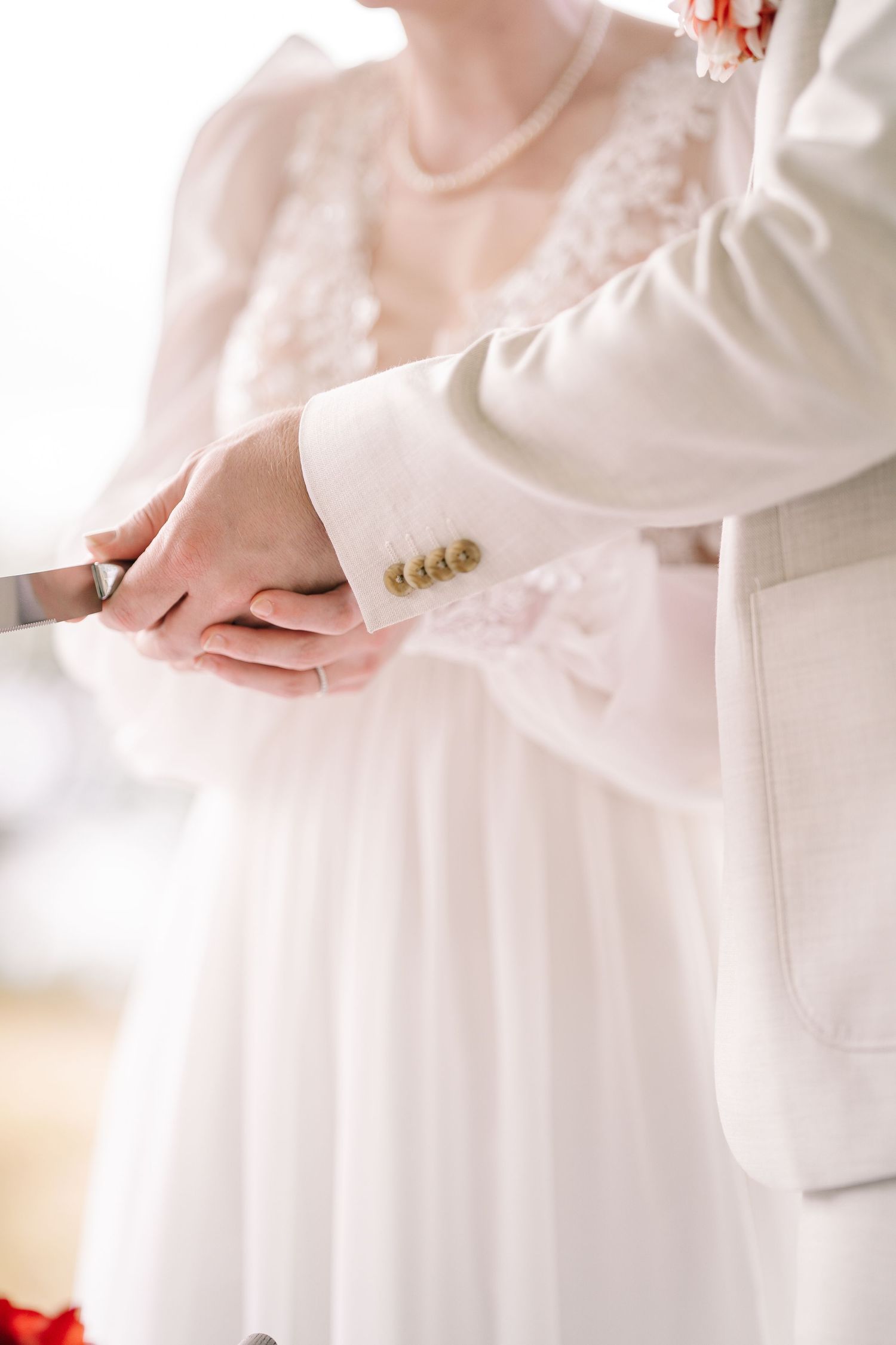 Person wearing flowing white dress fabric shown in close-up detail against neutral background.