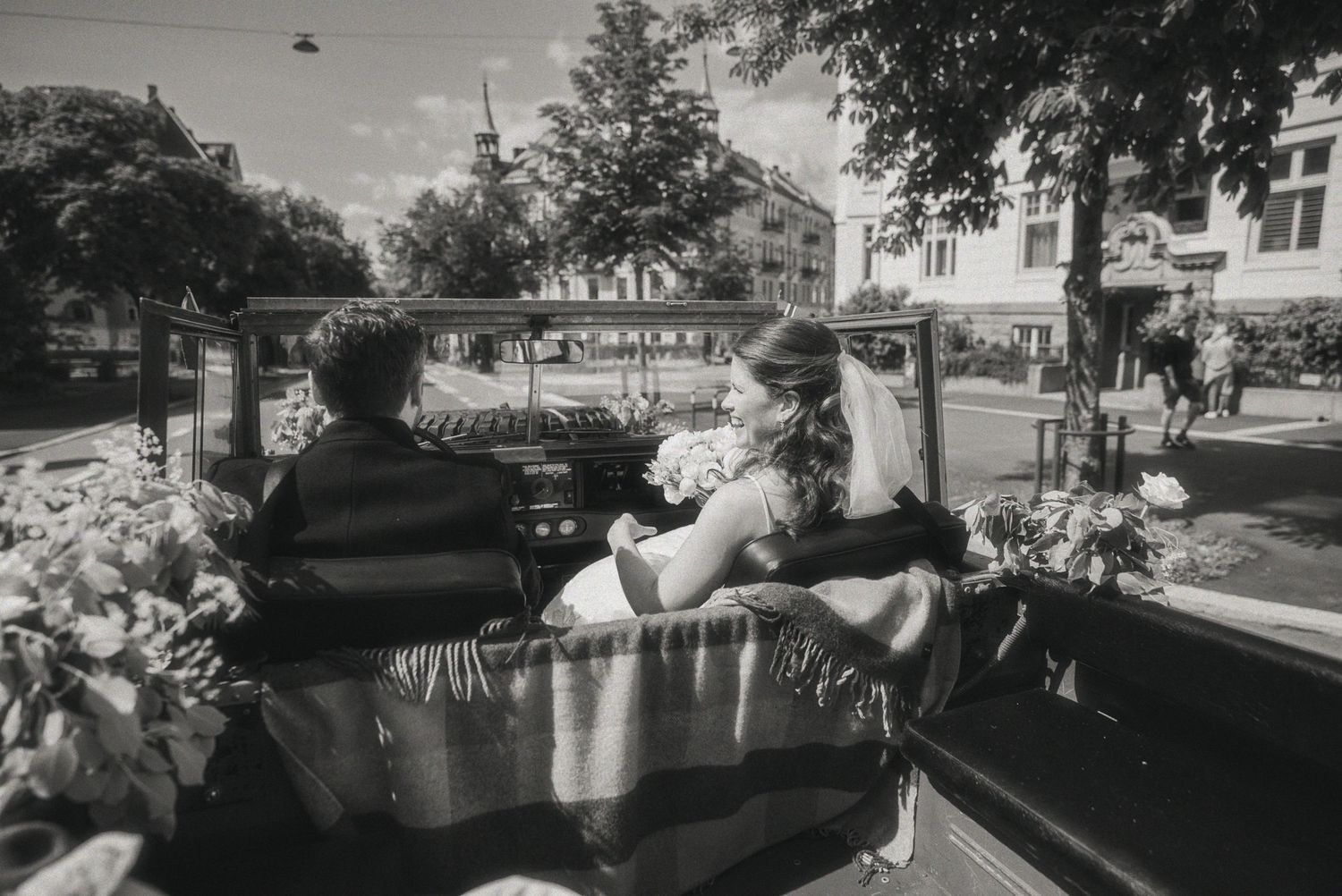 A sequence of wedding photos taken near a waterfront with trees and buildings in the background.