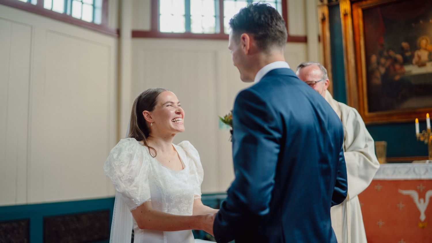 Candid moment of joy captured during indoor wedding celebration.