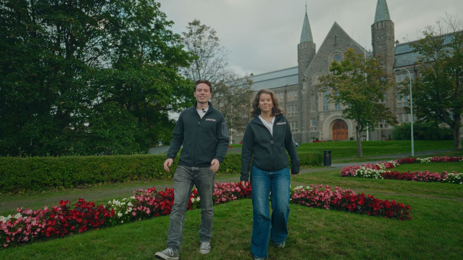 Panoramic view of a church garden with red flowers and walking paths.