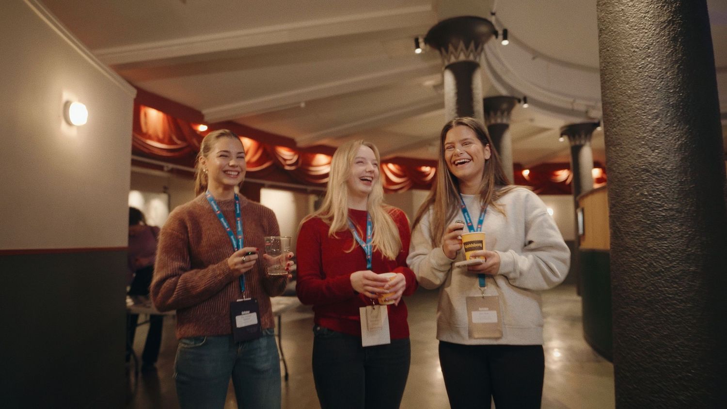Group of professionals socializing with beverages at an indoor corporate event.