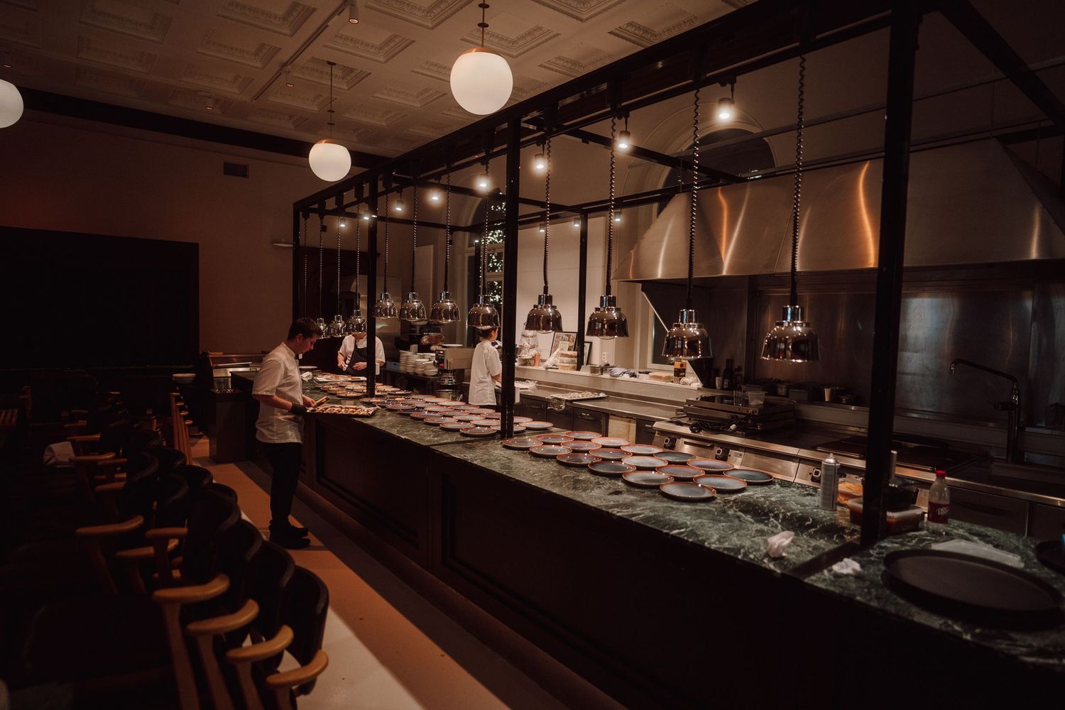 Modern restaurant interior with minimalist lighting and sleek bar setup.