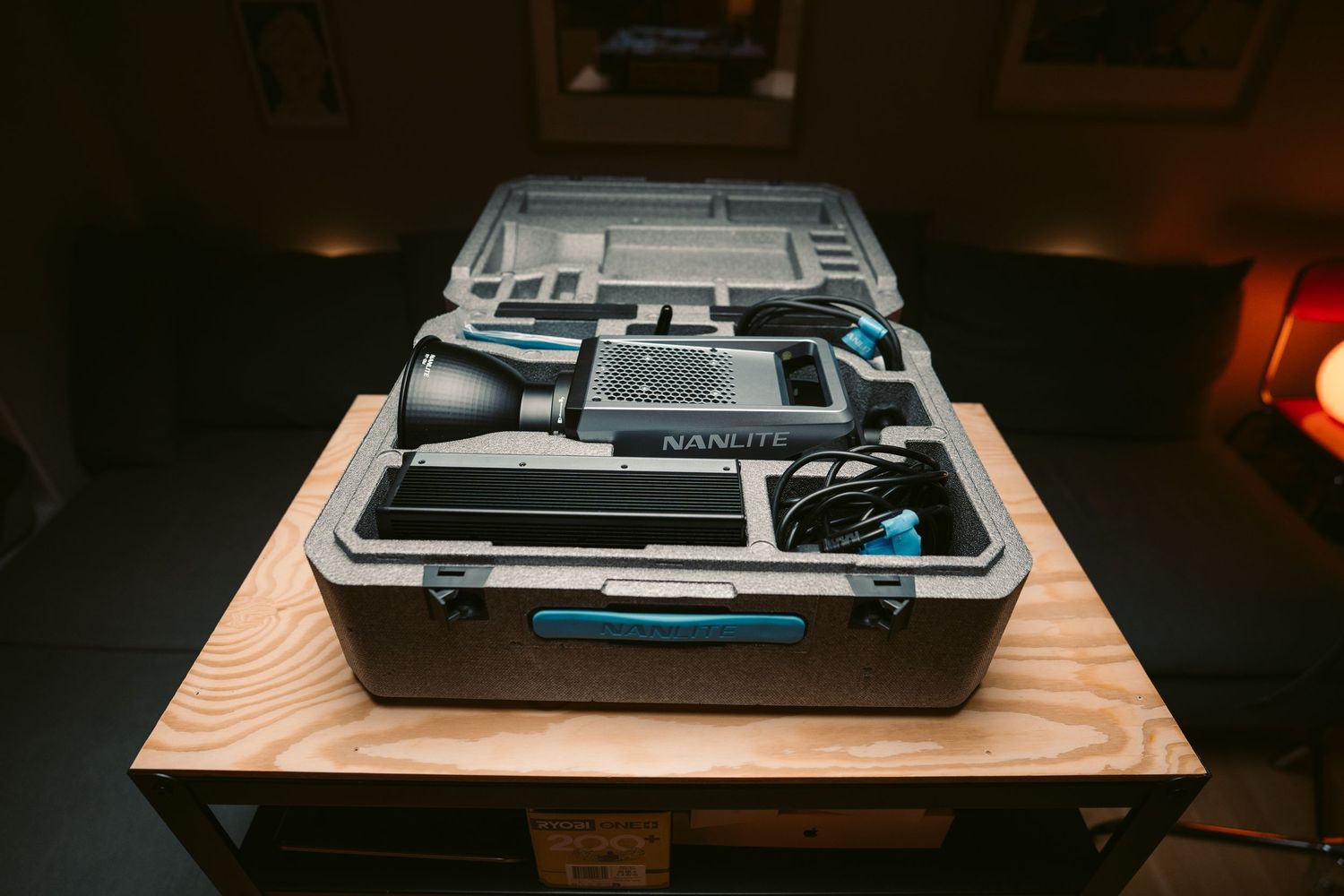 Professional camera equipment neatly organized in a gray hard-shell carrying case on a wooden table.