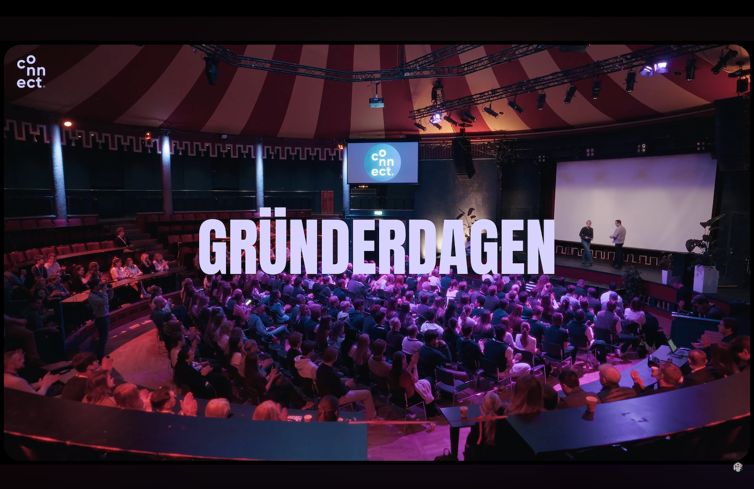 Large conference venue with purple lighting and crowded audience during Grunderdagen event.