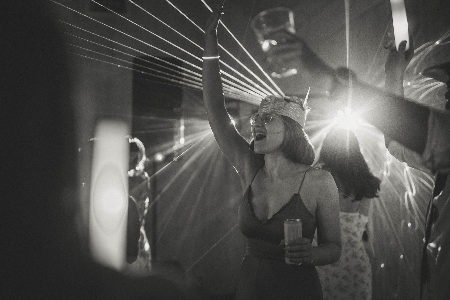 Black and white concert scene with dramatic lighting and silhouetted performers on stage.