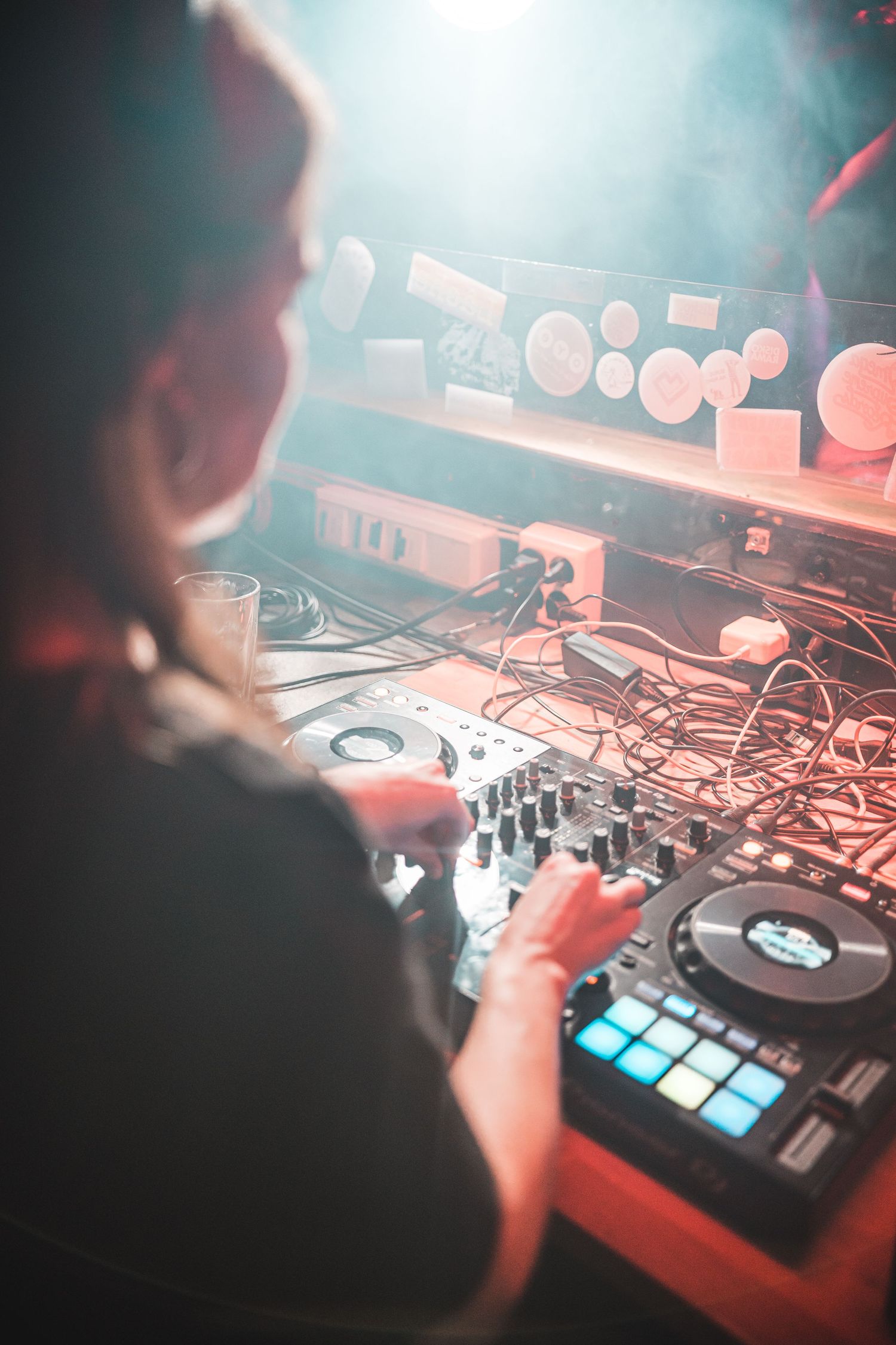 Close-up of DJ mixing equipment with dramatic stage lighting effects.