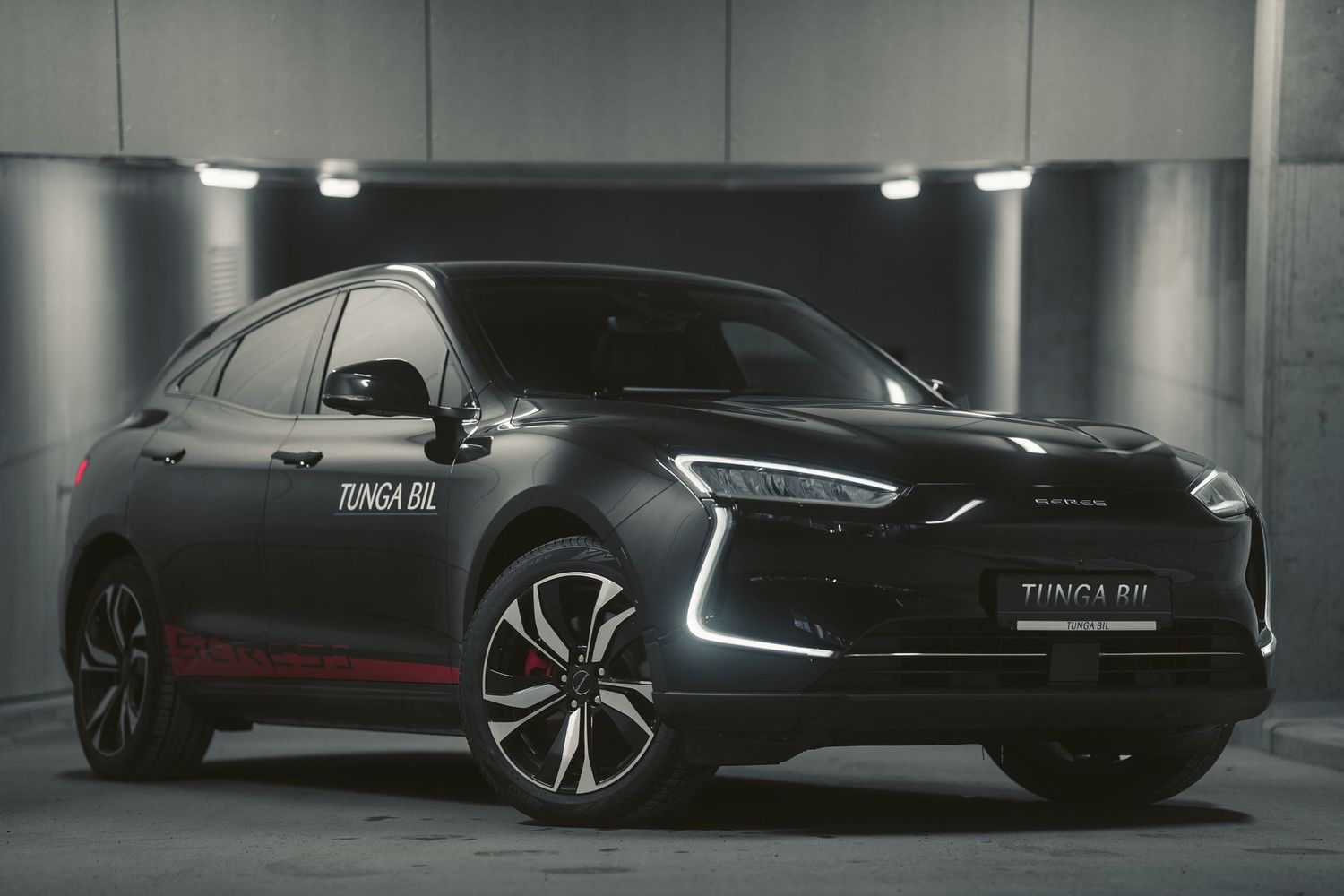 A sleek black SUV with distinctive LED lighting displayed in a dark parking garage.