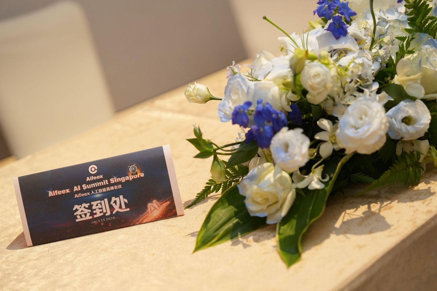 Elegant floral arrangement with white and blue flowers beside a Chinese sign-in card on a decorated table.