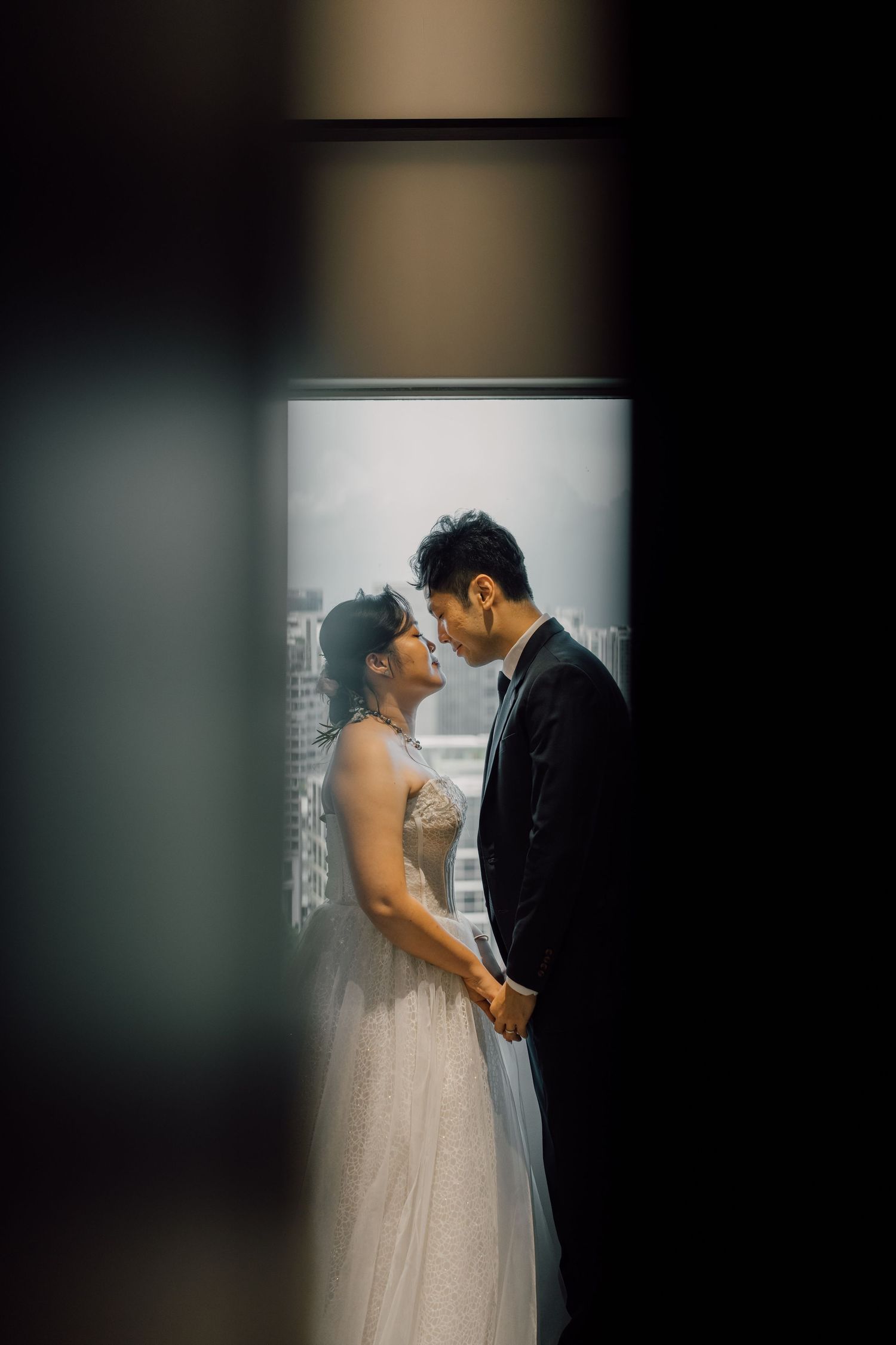 A wedding couple shares an intimate moment together during their photo session with artistic bokeh lighting.