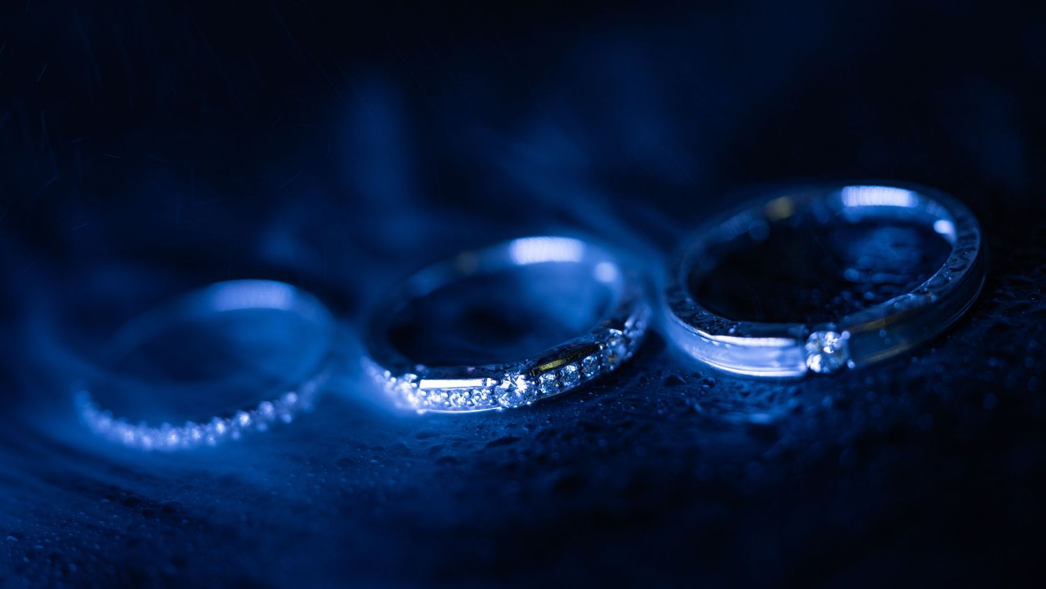 A blue illuminated fiber optic cable forms an elegant curve against a dark background.