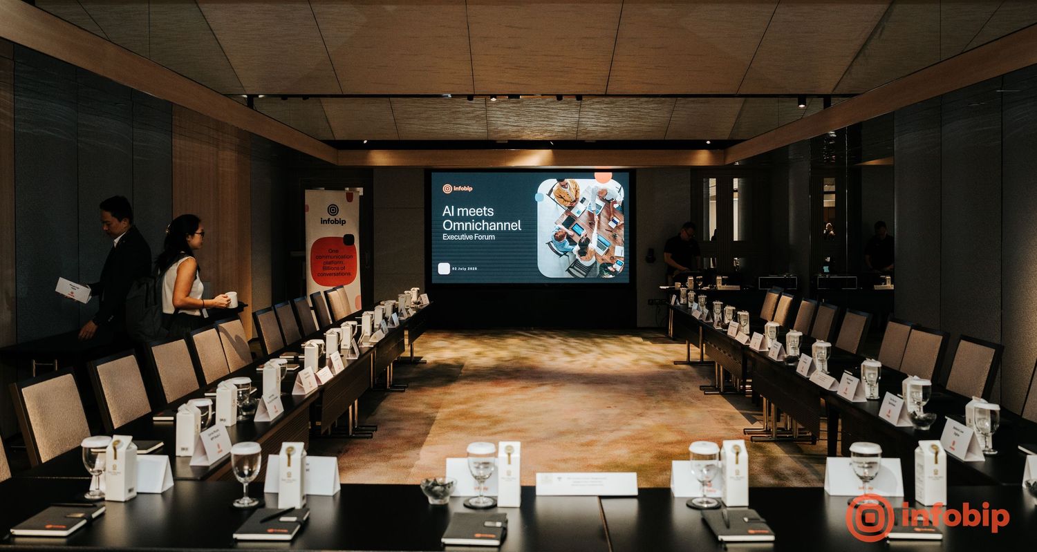 Modern conference room with U-shaped table setup, chairs, and a presentation screen displaying AI meeting content.
