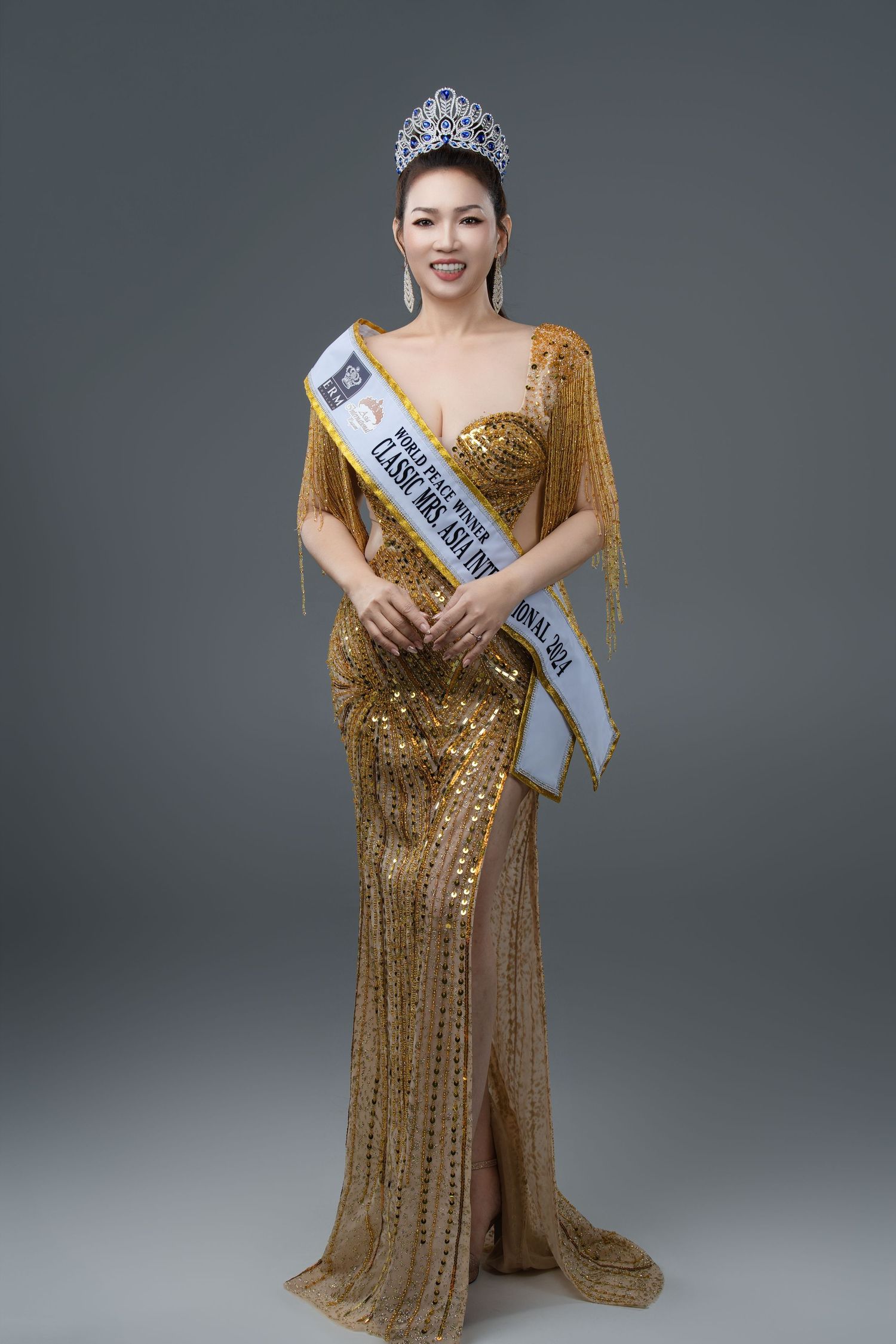 Woman in gold sequin gown wearing pageant crown and sash at a beauty competition.