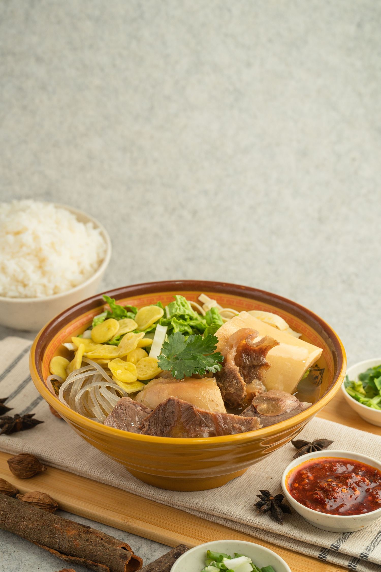 A hearty Vietnamese pho bowl with beef, tofu, bean sprouts, and herbs, served with rice and dipping sauce.